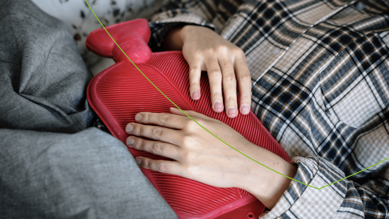 Vrouw ligt met een waterkruik op haar buik
