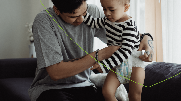 Vader doet luier aan bij baby
